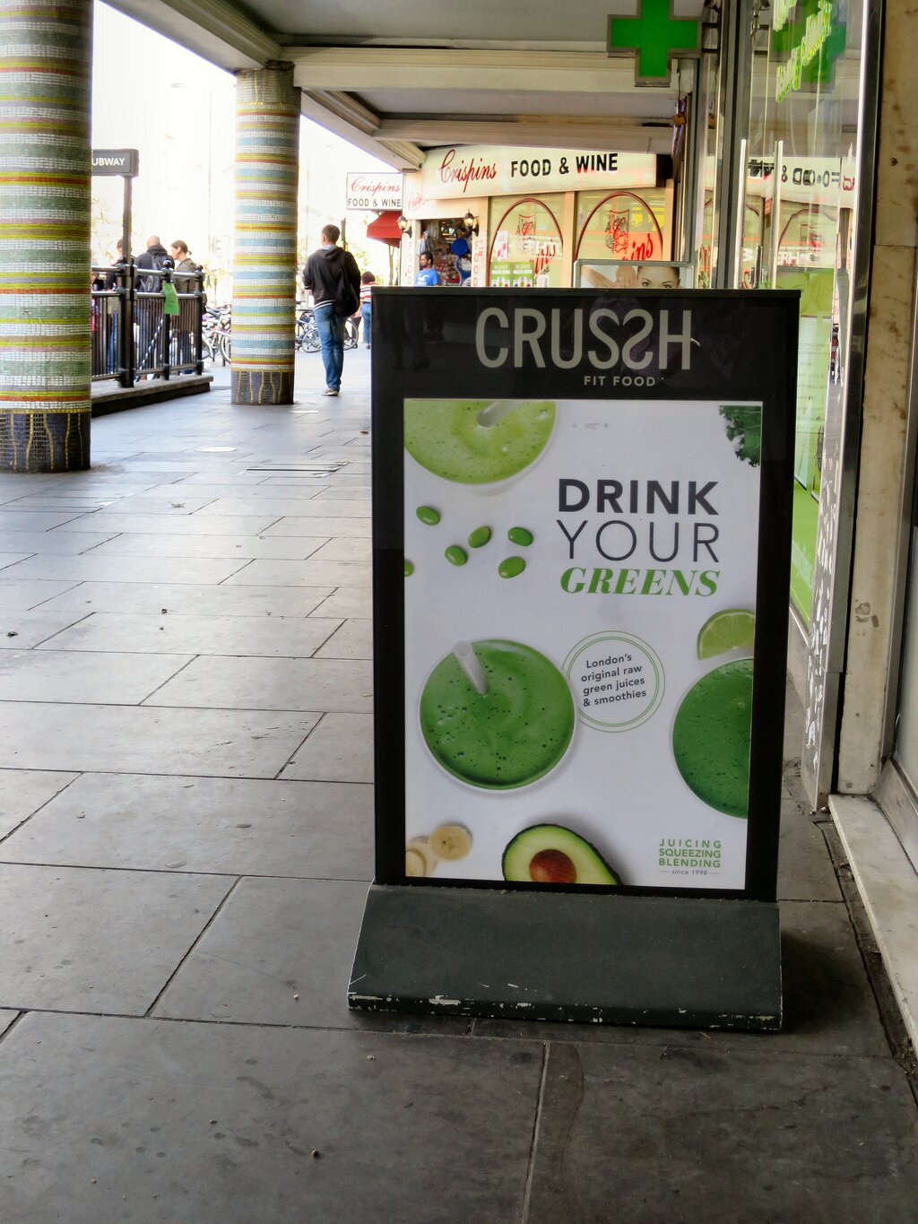 Londra kaldırımında "CRUSSH FIT FOOD" için A-çerçeveli bir tabela.